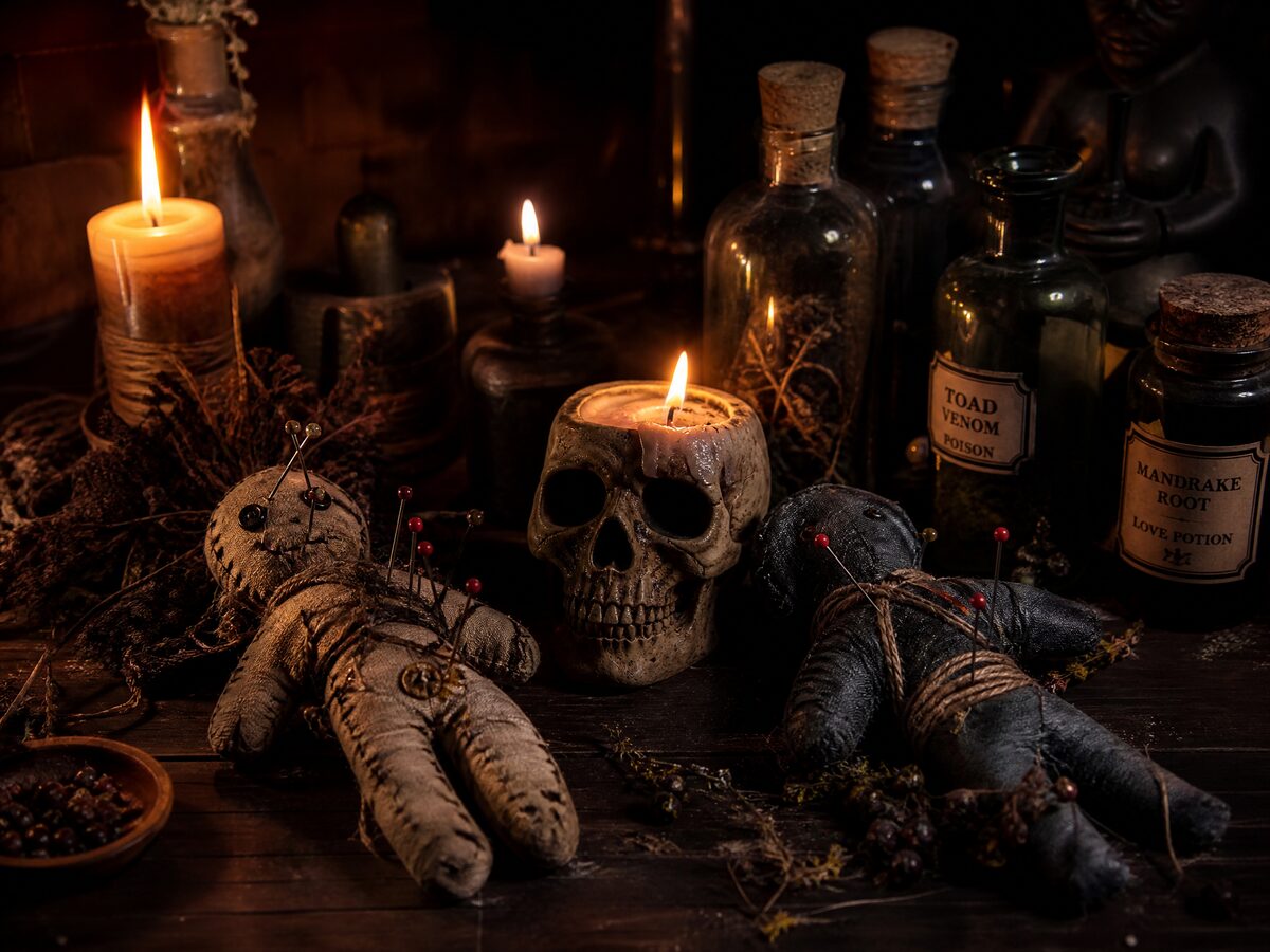 Antiker Voodoo-Altar mit Stoffpuppen, Totenkopfkerze und Kräutern